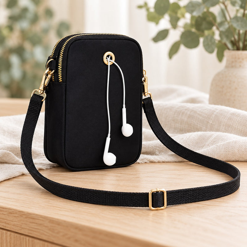 Plain black back of the mini crossbody bag with cable opening, detachable clips and adjustable strap