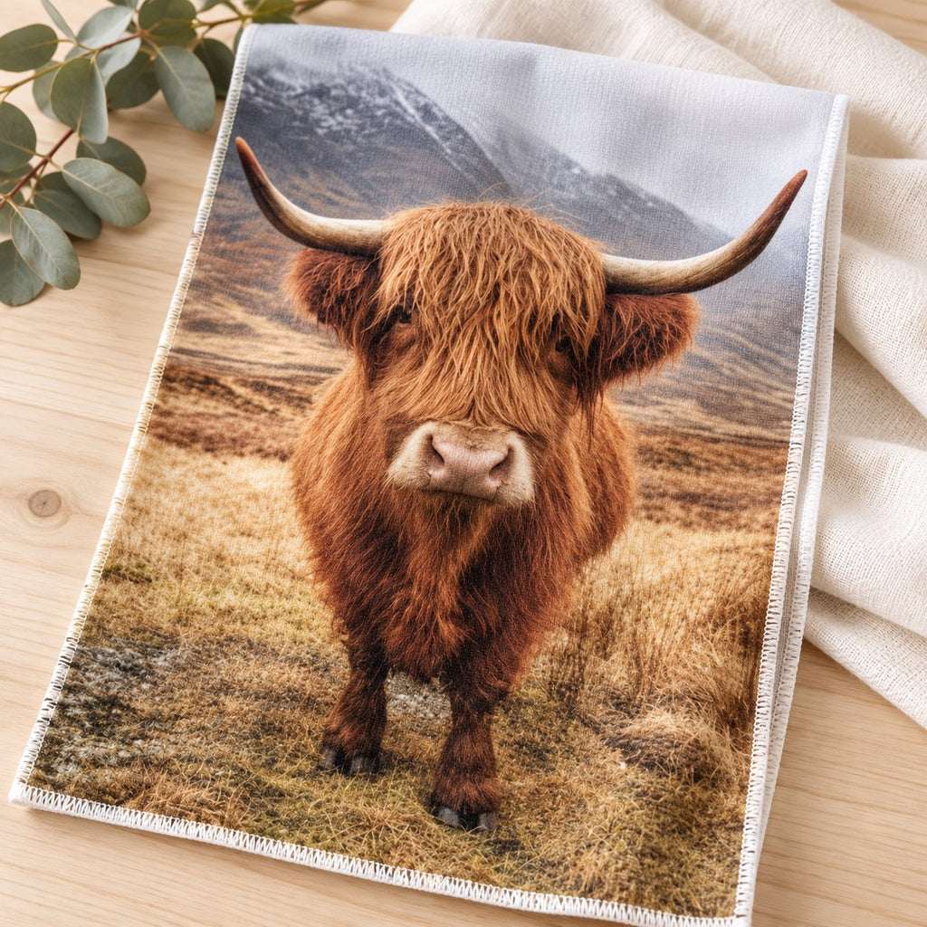 Close-up of the realistic Highland cow artwork printed on one tea towel. Sold individually; decorative props not included.