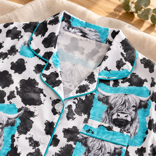 Close-up of the notched collar, white buttons, chest pocket and turquoise trim on the Highland cow pyjama shirt