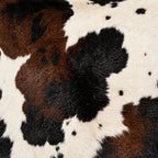 Close-up of the brown, black and cream cowhide-look print on polyester cushion fabric