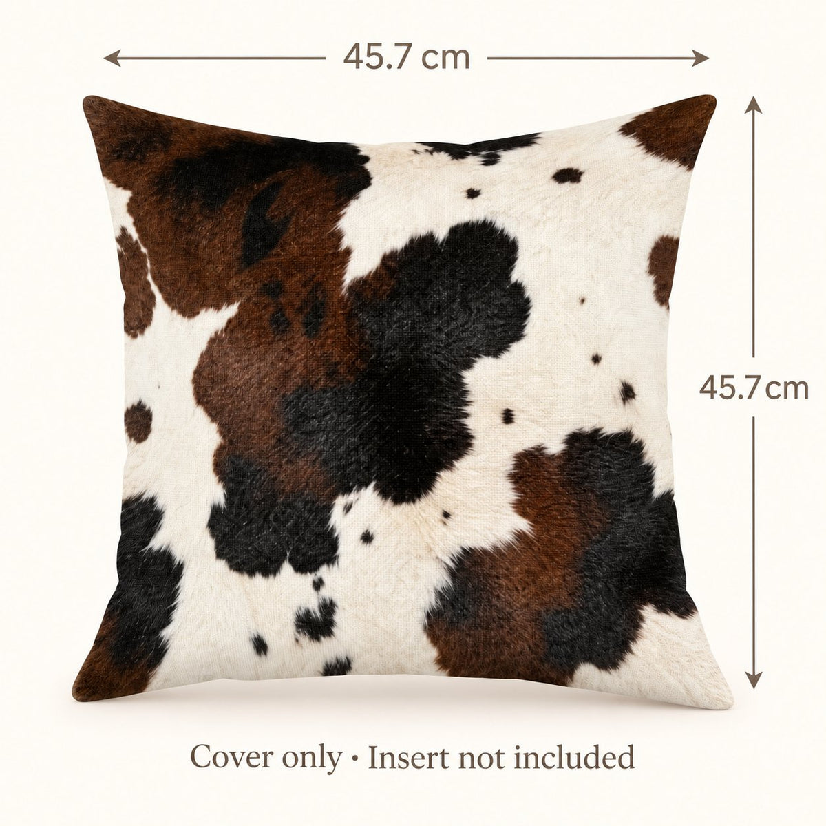 Brown and cream cow-print cushion cover with width and height marked 45.7 cm; insert not included