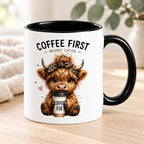 Coffee First Highland cow mug styled on pale timber with ivory linen and greenery; decorative props not included.