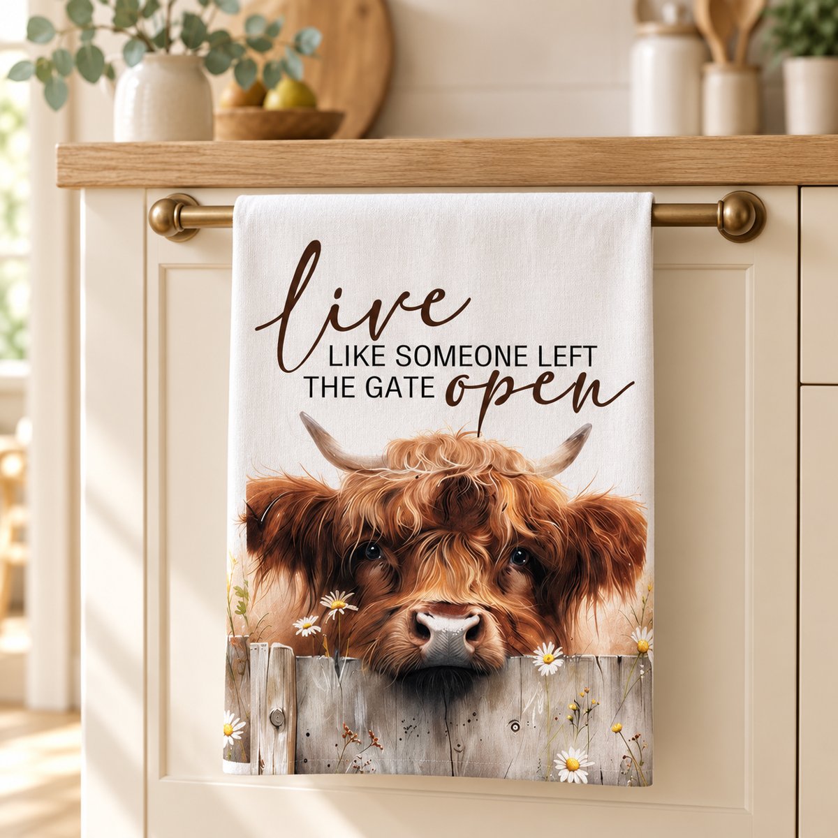 Live Like Someone Left the Gate Open Highland cow tea towel hanging in a cream country kitchen