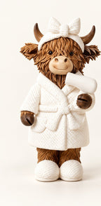 Individual Bathrobe Highland cow figurine in a white robe with a bow headband and hairdryer detail. One figurine.