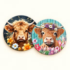 Close-up of two floral Highland cow coasters: golden cow with daisies and flower-crowned cow against turquoise boards.