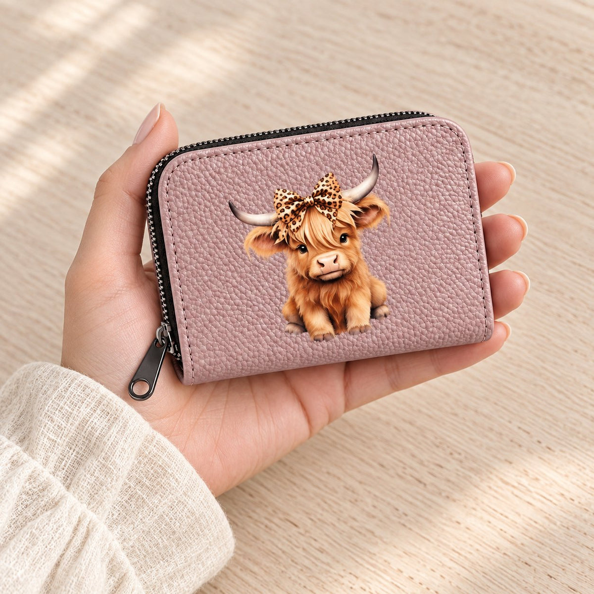 Pink Highland cow card holder held in a hand to show its compact size