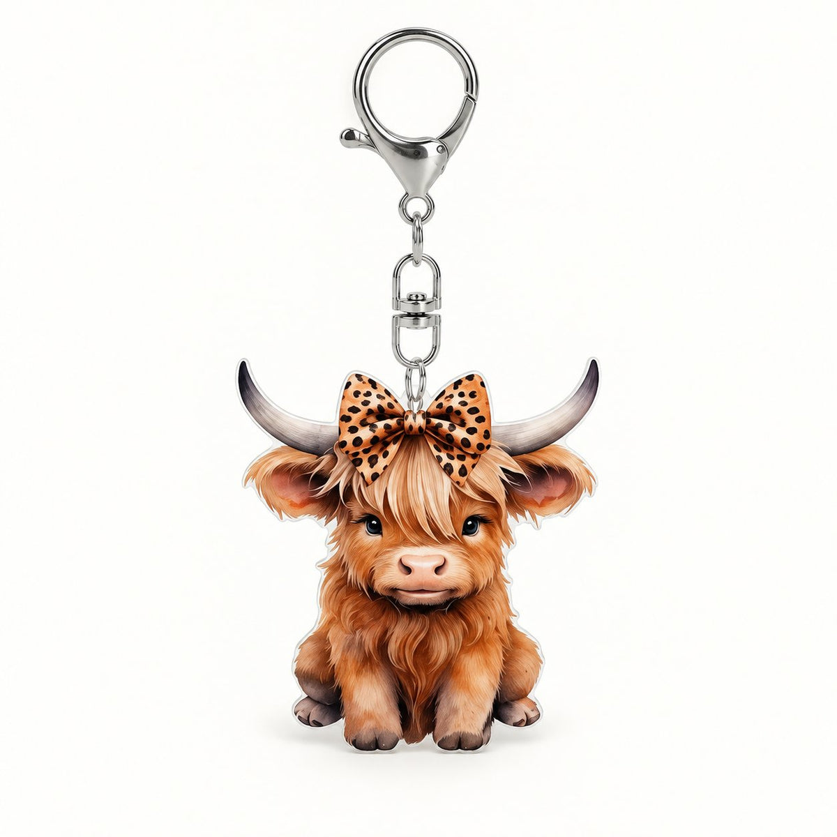 Highland calf clip-on keyring with a leopard-print bow and silver-coloured clasp on a clean background.