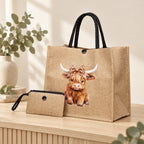 Styled view of a khaki Highland cow leopard-bow tote with black handles and coordinating plain purse on a timber surface; decorative props are not included.