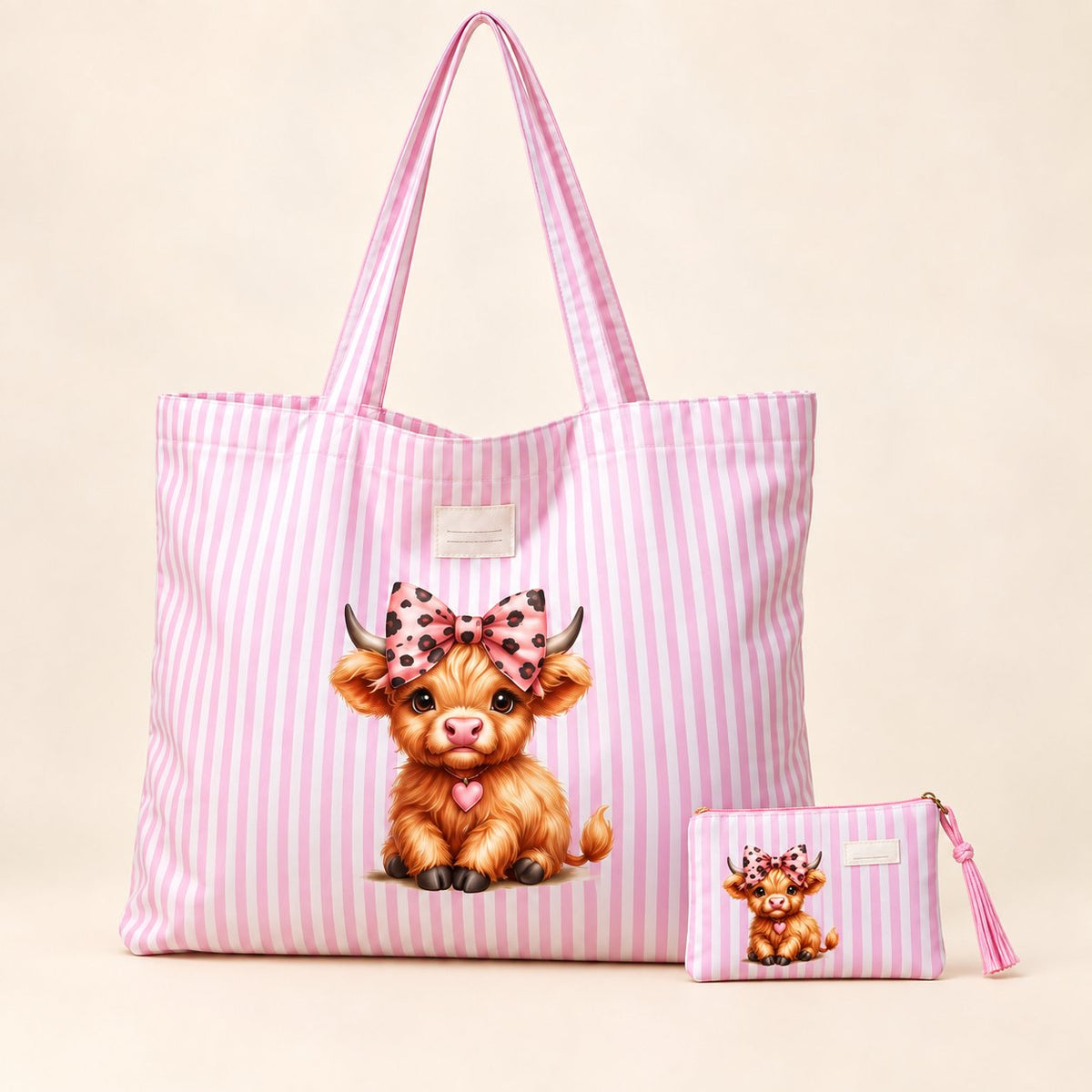 Pink-and-white striped Highland cow tote with matching small zipped purse, featuring a golden calf with a pink spotted bow and heart detail.