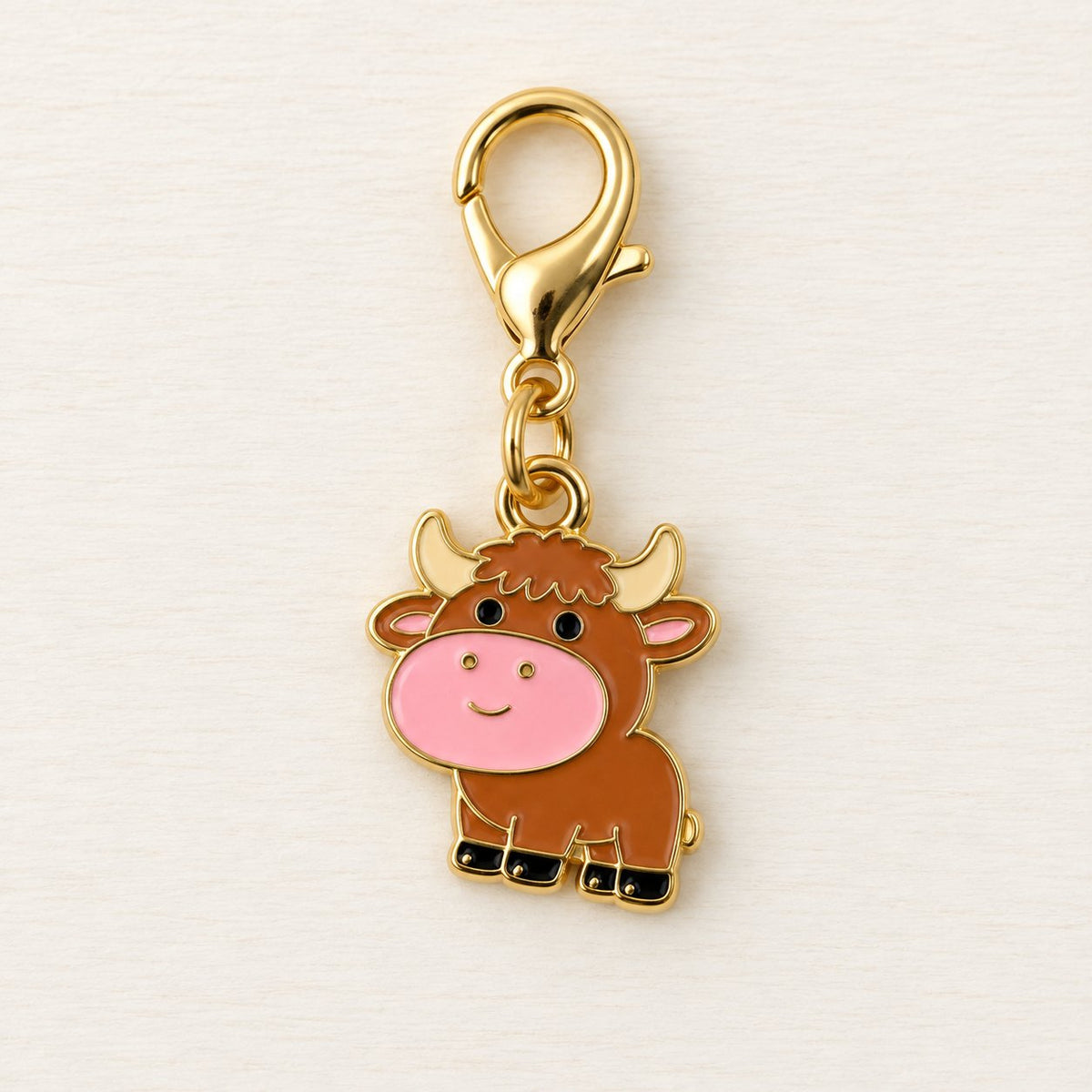 Close-up of brown calf charm with pink muzzle, cream horns and gold-coloured clasp