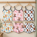 Pink Cow, Black Bow and Sunflower ladies pyjamas displayed on wooden hangers