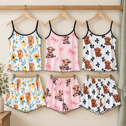Pink Cow, Black Bow and Sunflower ladies pyjamas displayed on wooden hangers