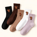 Highland cow crew socks in black, chocolate brown, camel, white and pale mauve on an ivory background. Choose one pair in your preferred colour.