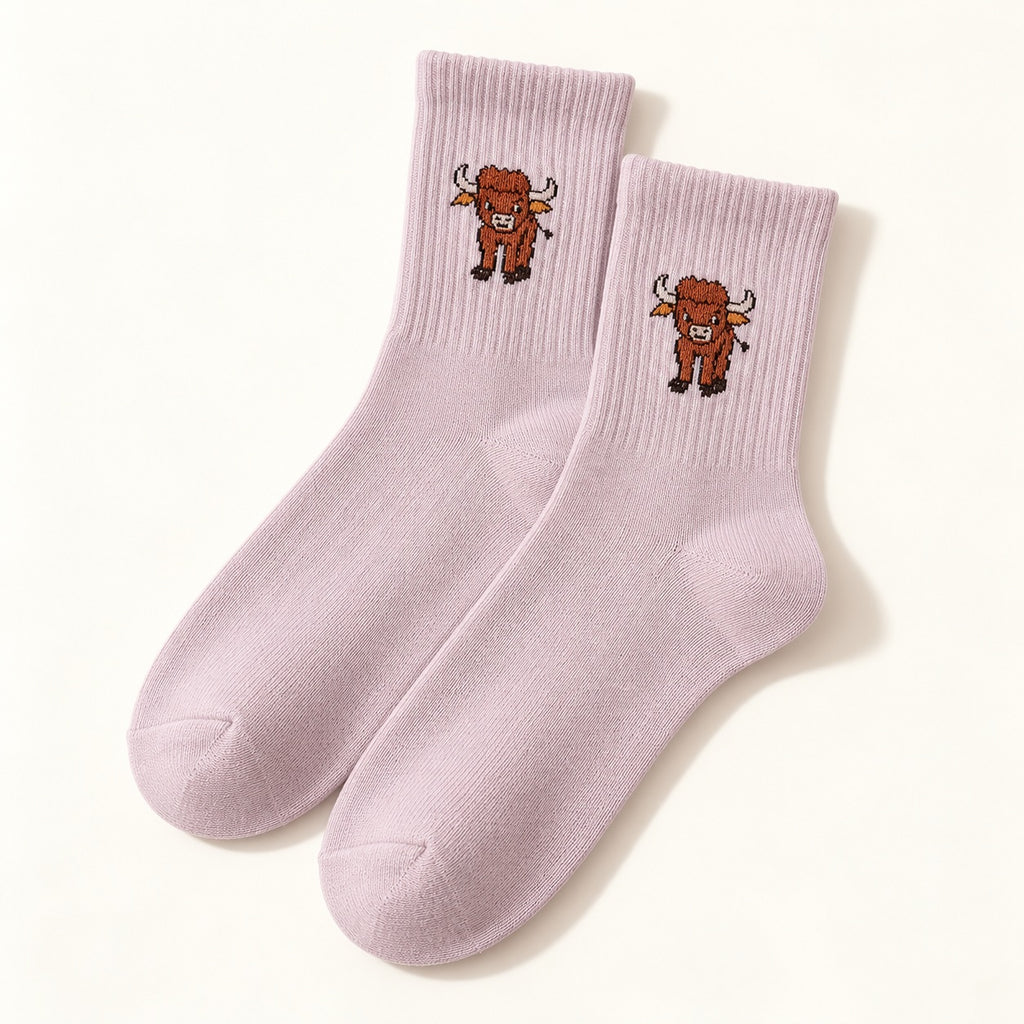 One pair of pale mauve Highland cow socks with ribbed cuffs and a small cow motif, shown on an ivory background.
