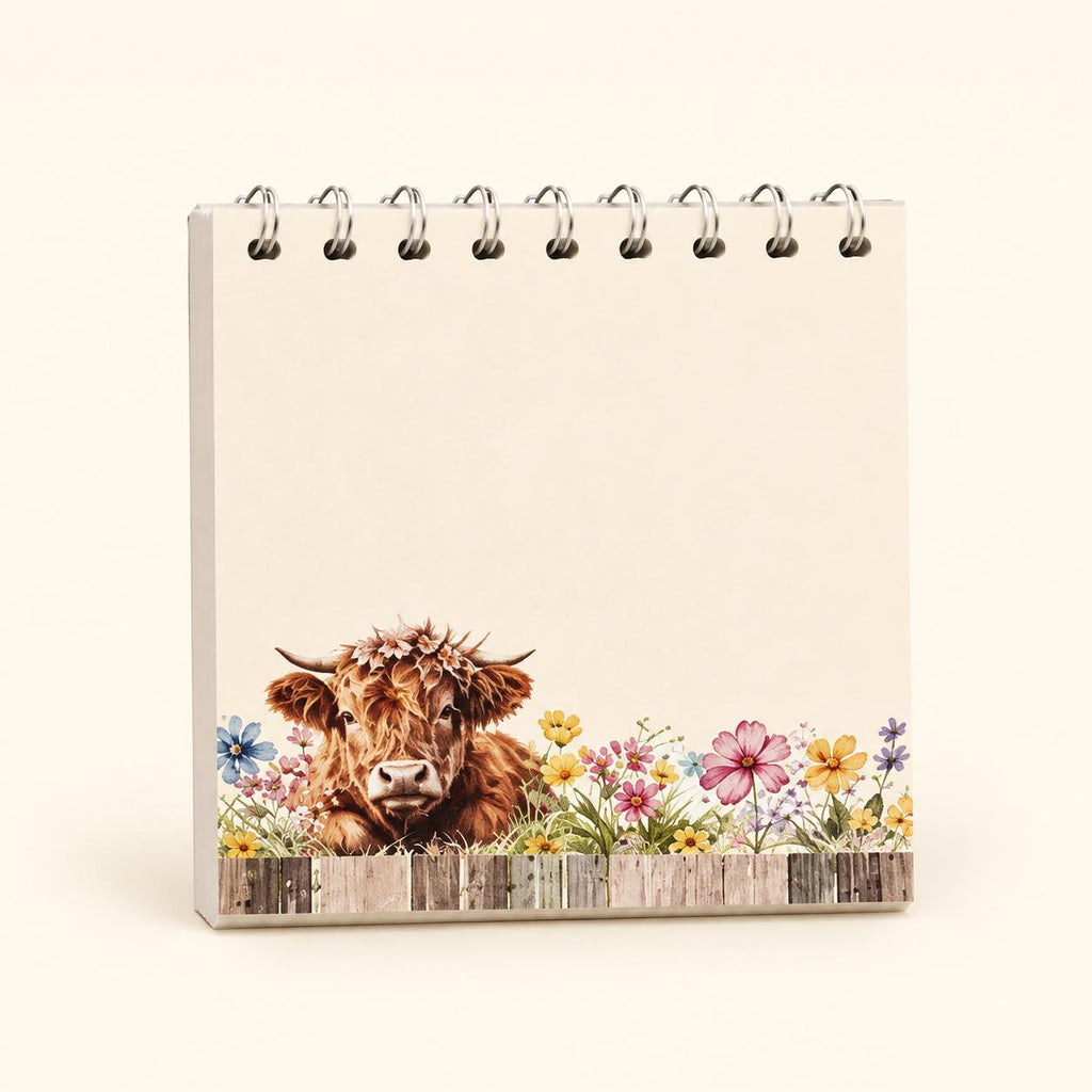 Floral Fence Highland cow sticky-note pad with colourful flowers, a wooden fence and spiral detail across the top.