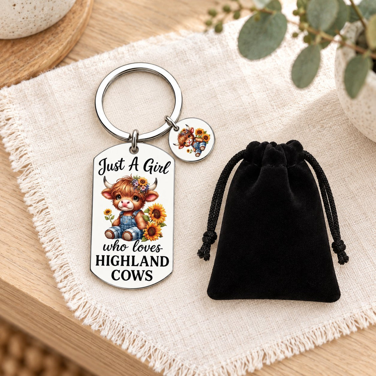 Highland cow keyring and included black gift bag styled on ivory linen and pale timber