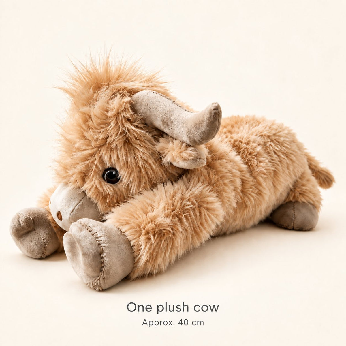 One tan Highland cow plush in a lying pose, with a size label reading Approx. 40 cm.