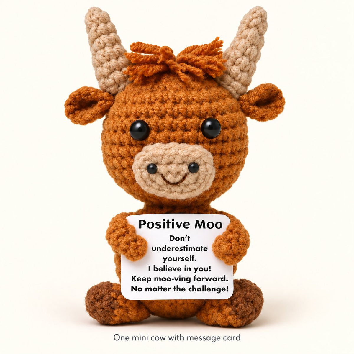 One brown mini knitted Highland cow with its included Positive Moo message card