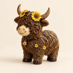 Bell Cow Highland cow figurine with yellow sunflowers, brown textured fur and a gold-coloured bell on an ivory background