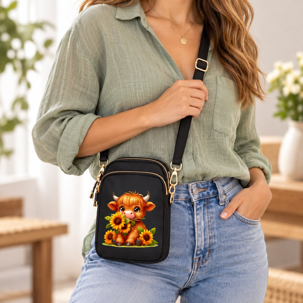 Sunflower Highland cow mini crossbody bag worn across the body to show its compact size and shoulder strap.